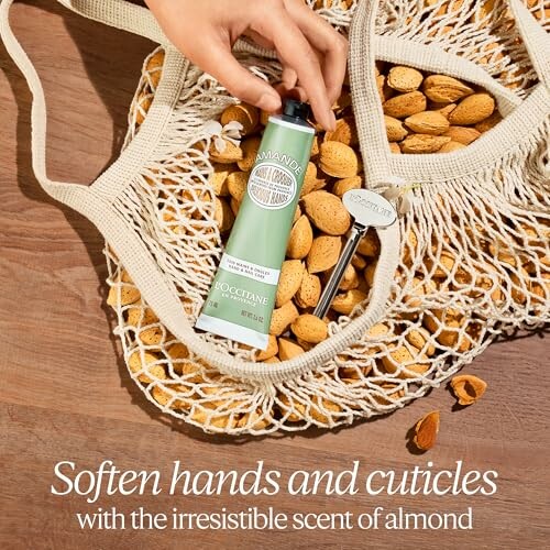 Hand holding almond hand cream in a net bag filled with almonds.