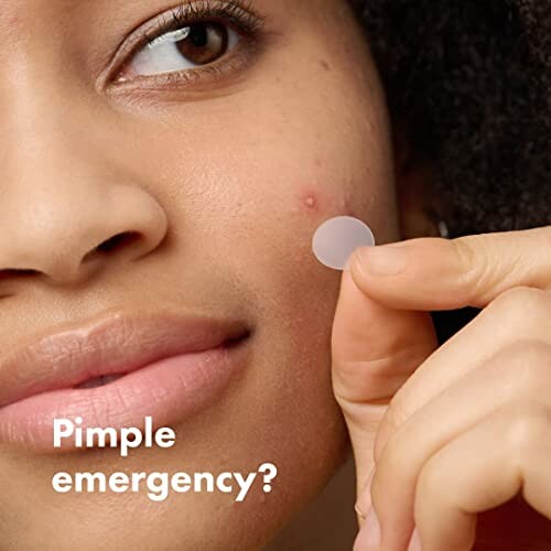 Person applying a pimple patch on their face.